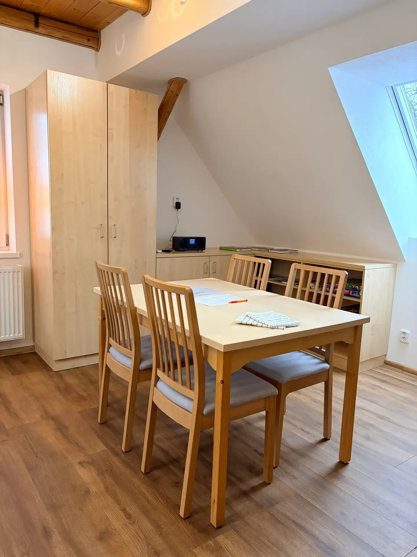 Jídelní stůl se čtyřmi židlemi u okna v apartmánu 1