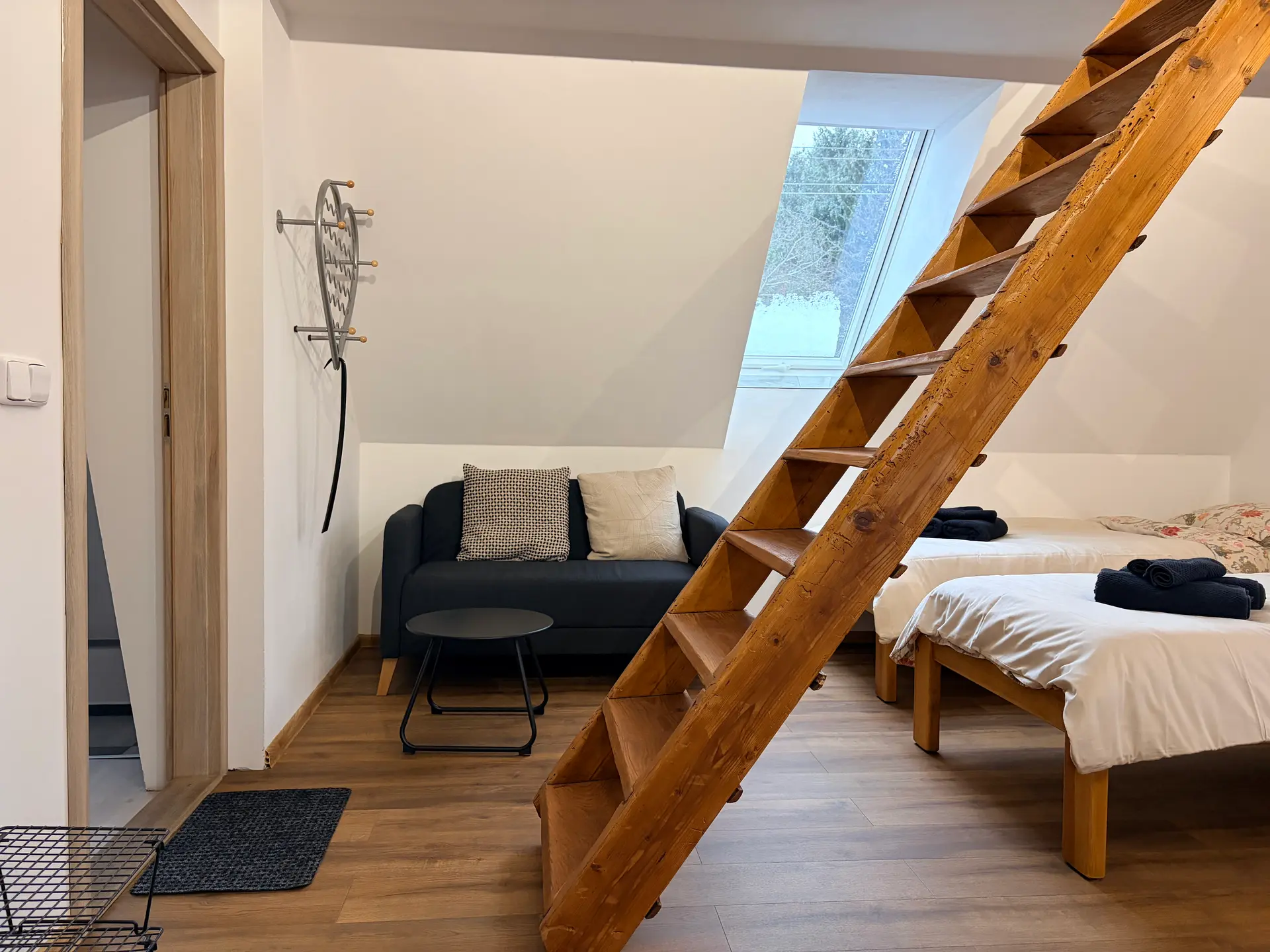 Interiér apartmánu 1 se šikmým stropem a střešním oknem