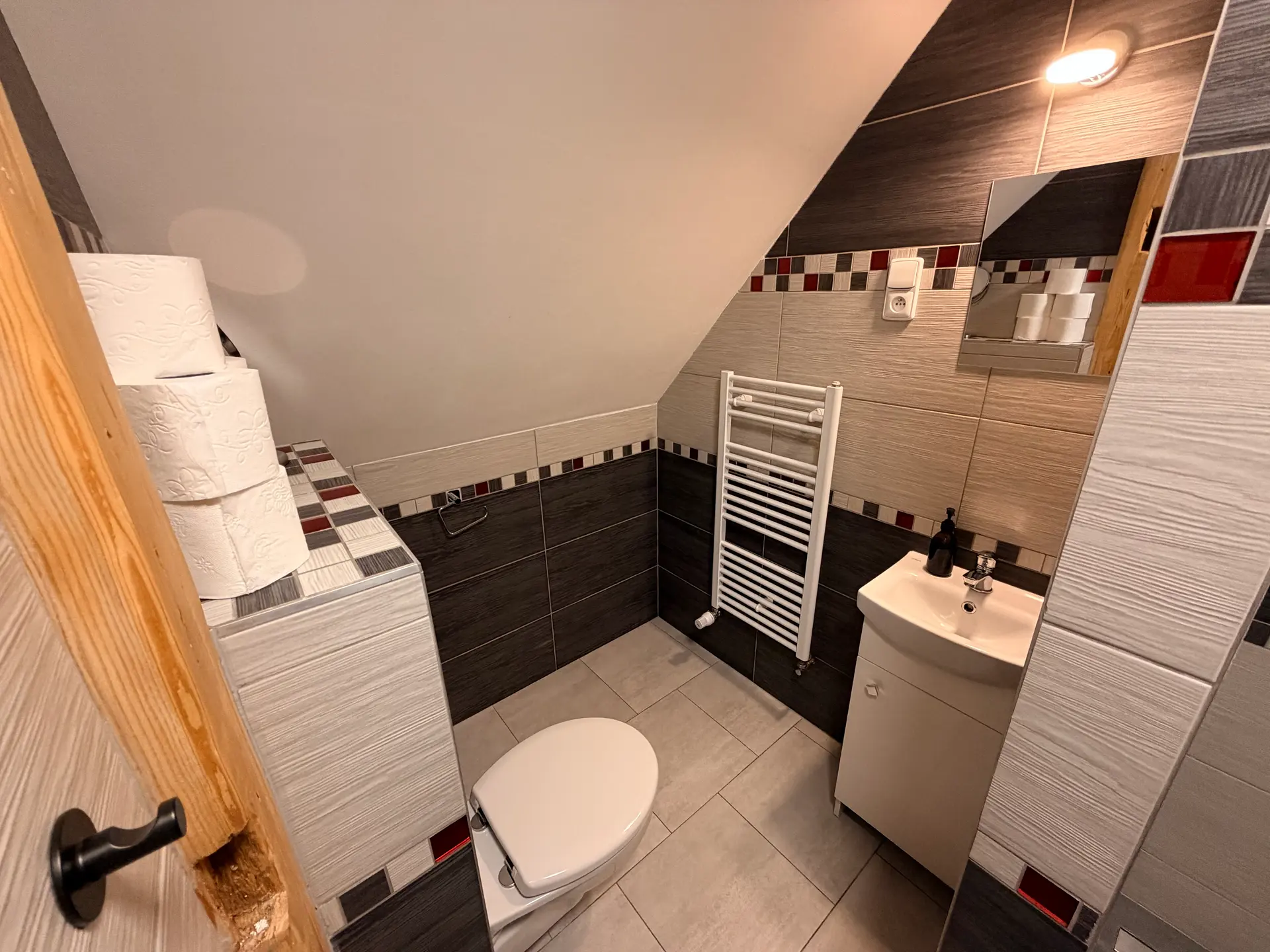 Koupelna apartmánu 1 s umyvadlem, toaletou a topným žebříkem