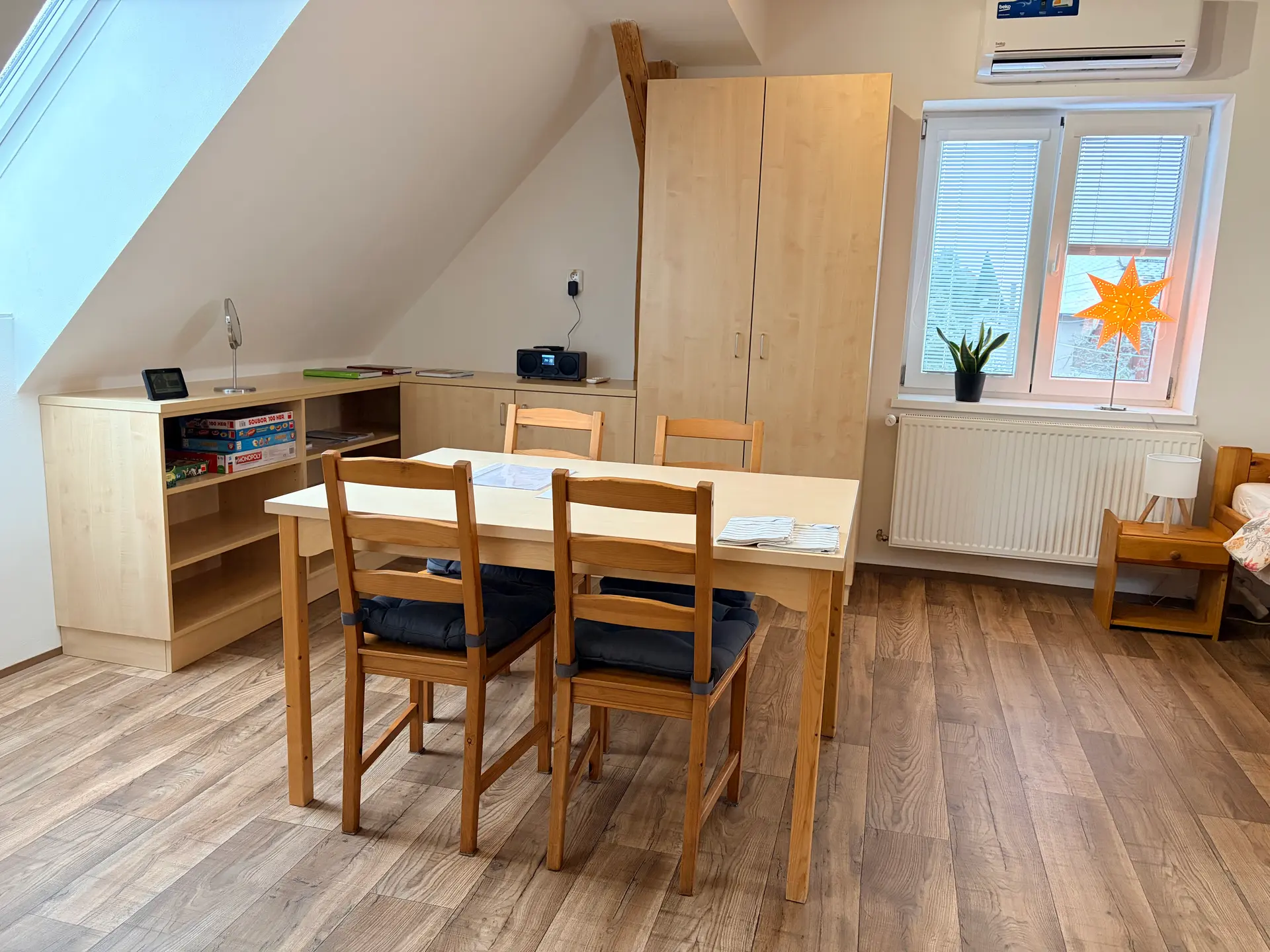 Jídelní kout apartmánu 2 se stolem, skříní a knihovnou